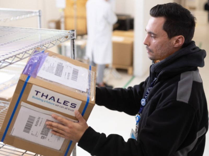 Thalesin logistiikkatyöntekijä pakkaamassa laatikoita rullakkoon.
